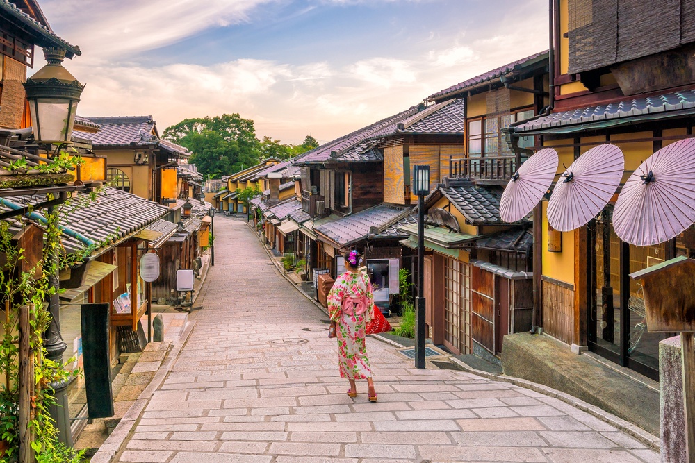 Japanese girl in Yukata with red umbrella in old town Kyoto, Japan