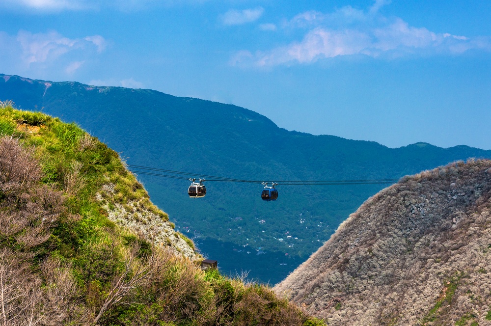 Mountain ropeway, cable car with slopes covered with green trees and fog, mist. Owakudani, Hakone