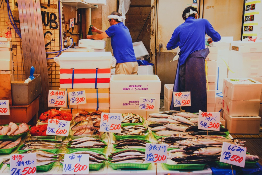 Japanese fishmonger preparing and packing fish into foam box at Tsukiji Fish Market in Tokyo, Japan