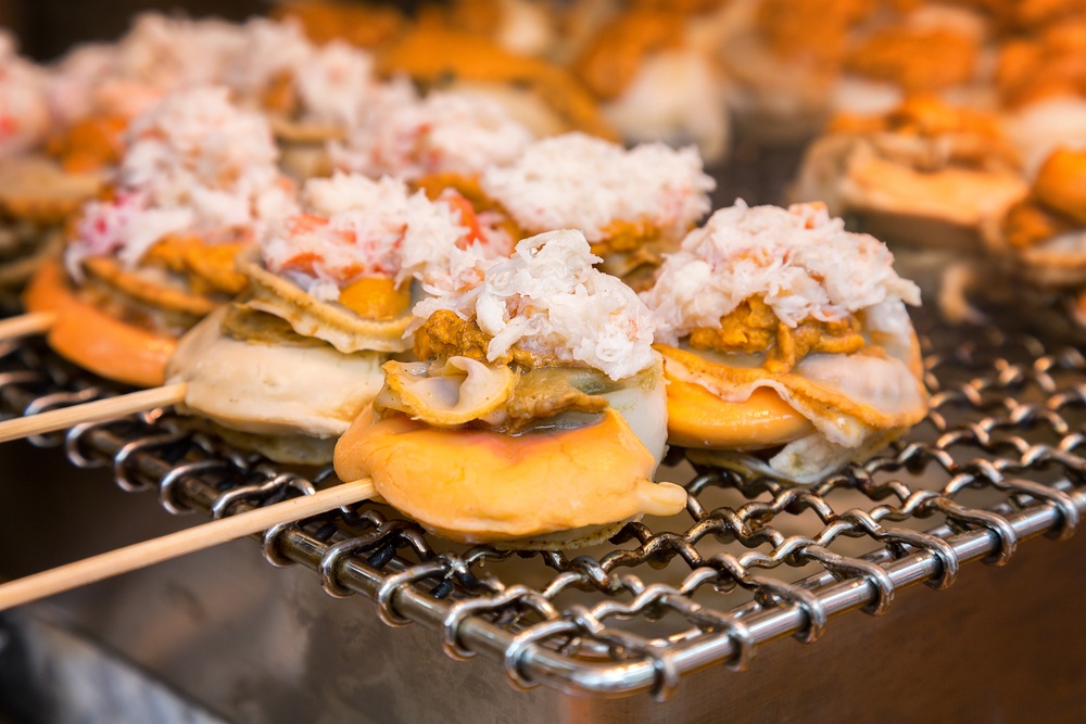Japanese street food consisting of griddled scallop with roe, sea urchin and crab meat