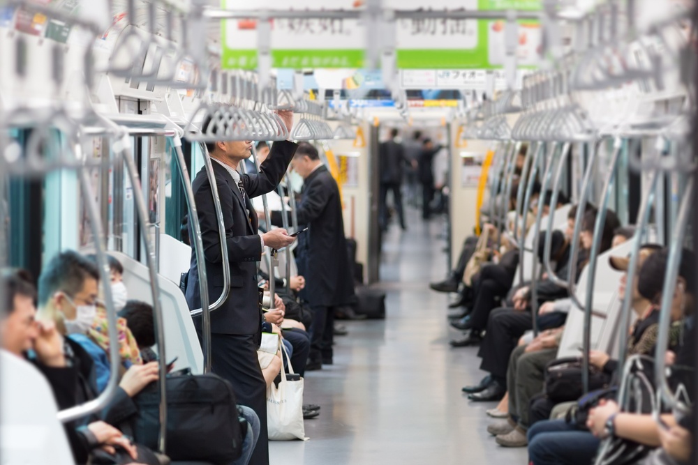 Passengers traveling by Tokyo metro. Business people commuting to work by public transport in rush hour
