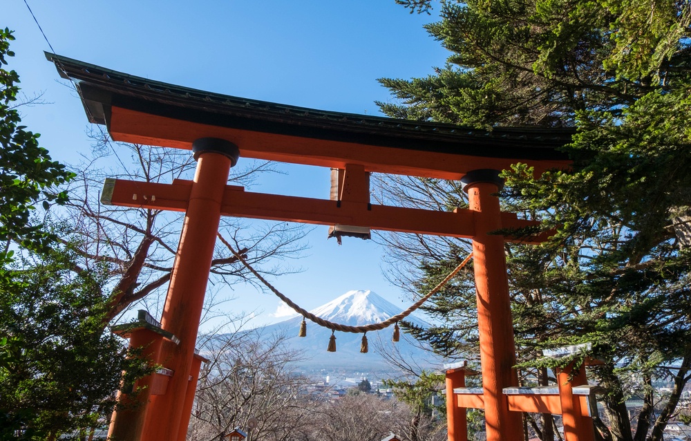 Red torii of Chureito temple with Mount Fuji as background. The gate and rope look like smile