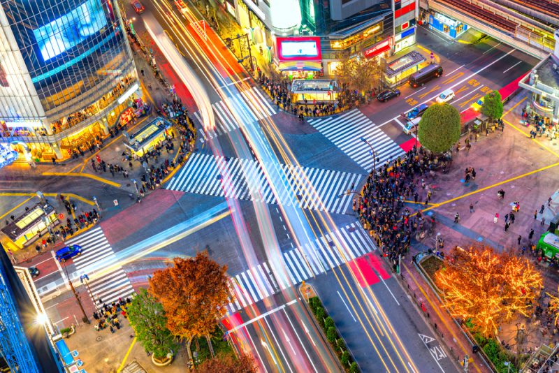 Aerial view of Shibuya Crossing, Tokyo. The scramble crosswalk is one of the largest in the world. Long exposition with light trail
